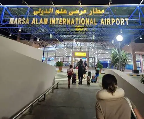 Reisende gehen vom Parkplatz zur Abflughalle am Flughafen Marsa Alam