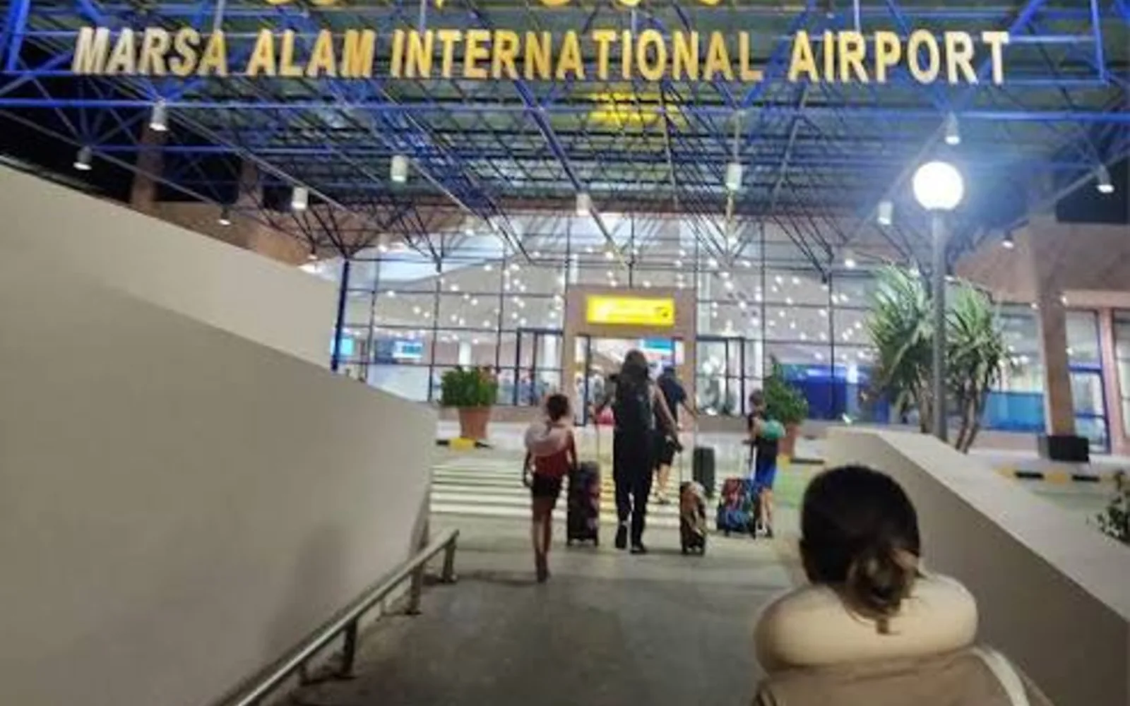 Reisende gehen vom Parkplatz zur Abflughalle am Flughafen Marsa Alam